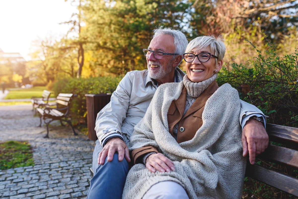 Retired Couple Sitting On Bench