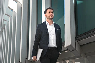 Man walking past office with laptop