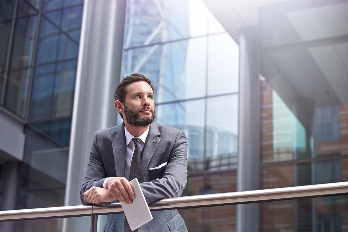 Man leaning over rail in office