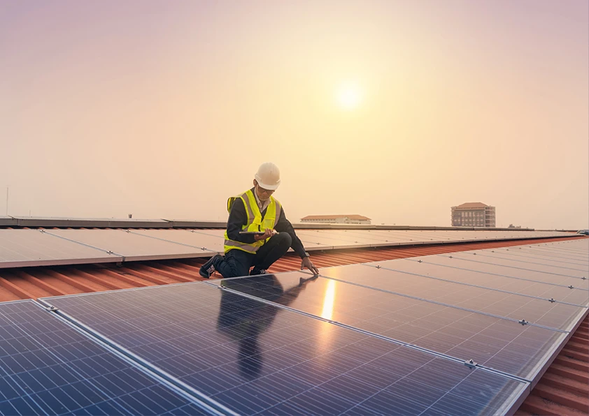 Man working on solar panels at sunset