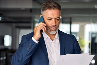 Man on phone looking at papers